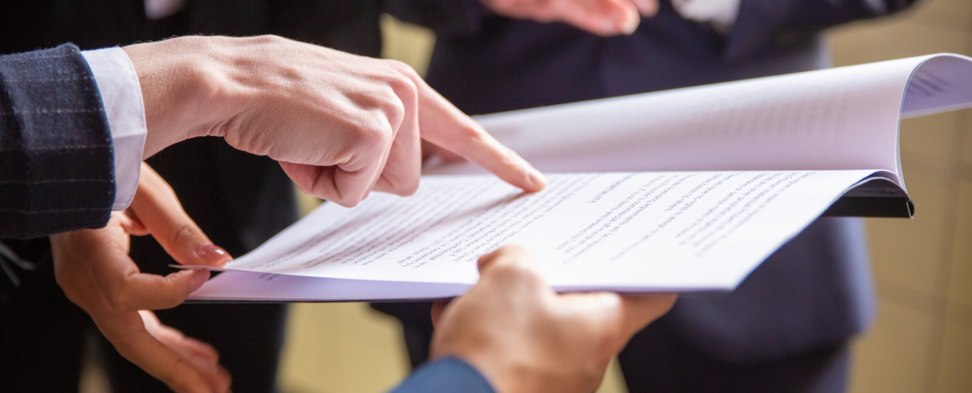 Manos señalando un documento abierto