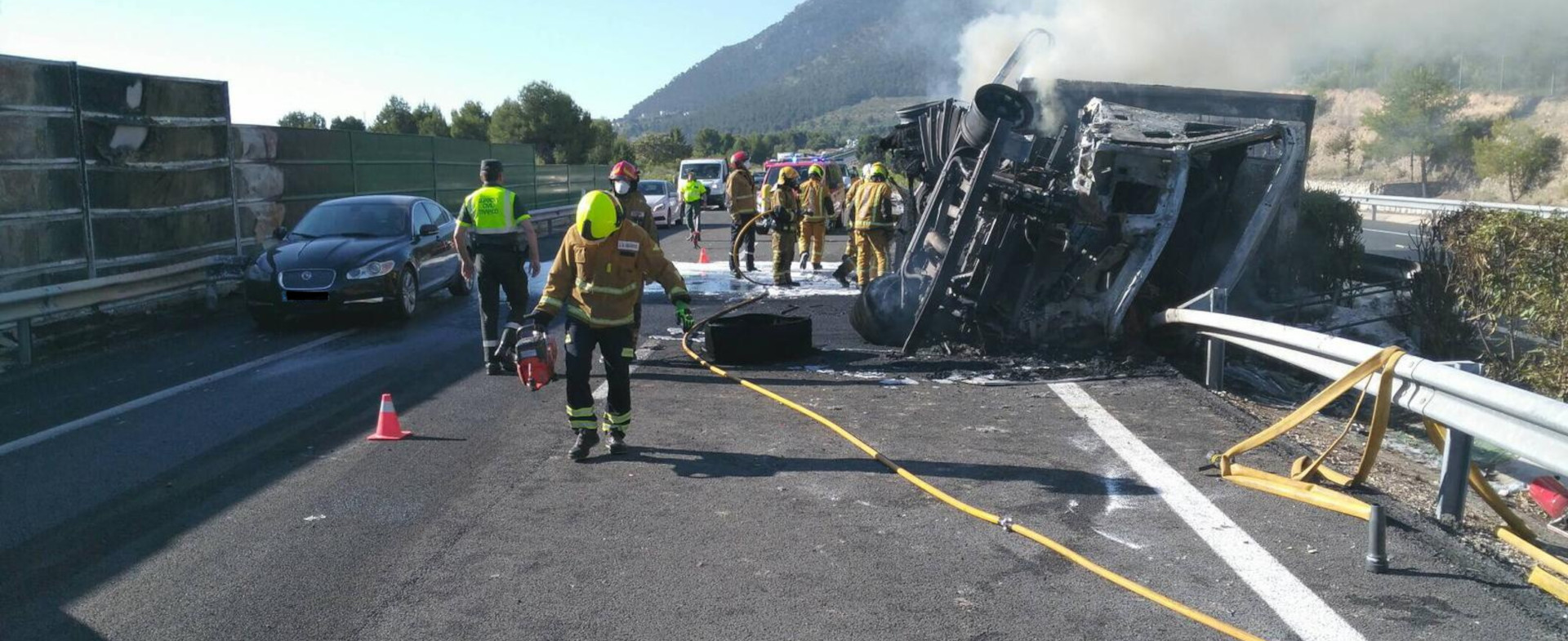 Dispositivo de bomberos atendiendo un accidente de tráfico de un camión Dispositivo de bomberos atendiendo un accidente de tráfico de un camión