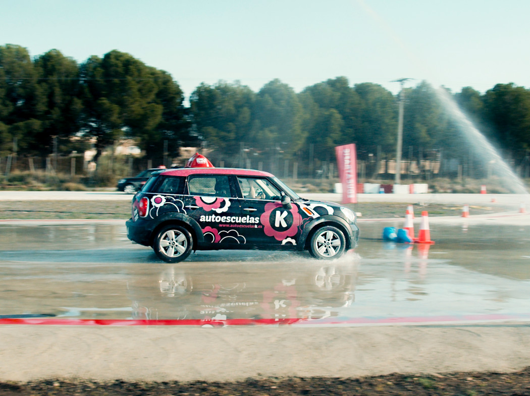 Coche circulando por una pista de pruebas mojada