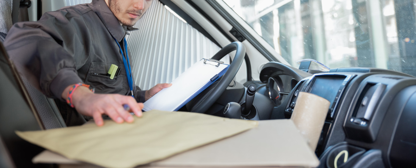 Transportista dentro de vehículo con sobres