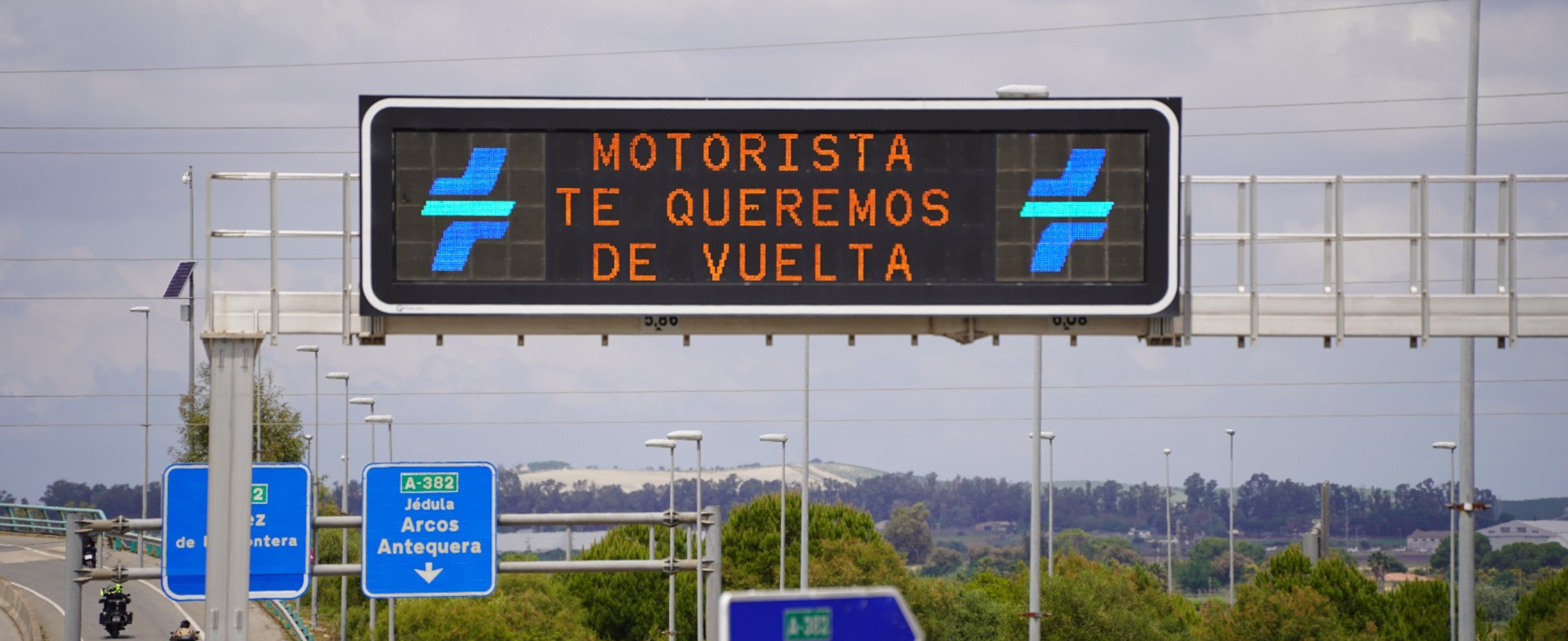 Fotografía de un cartel luminoso de carretera en el que se puede leer Motorista te queremos de vuelta.