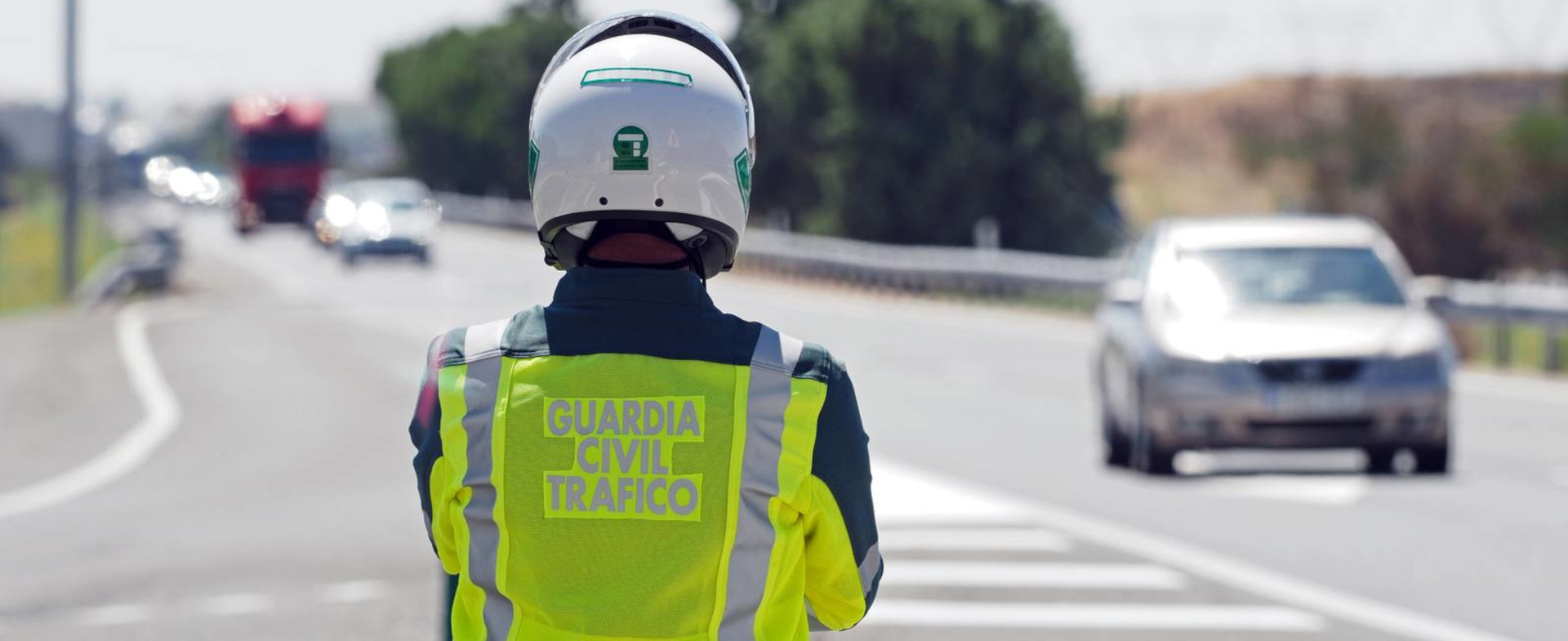 Agente de la Guardia Civil de espaldas observando una autopista.