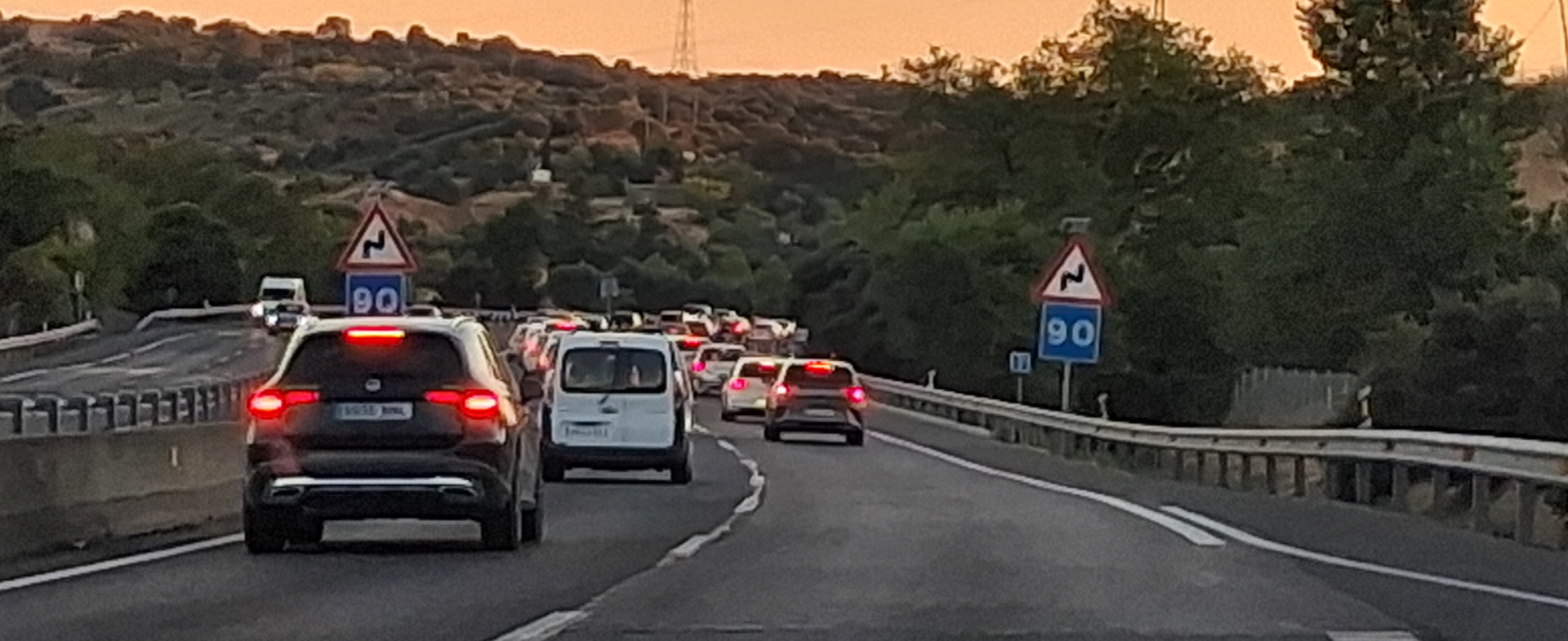 Vehículos circulando por una autopista al atardecer