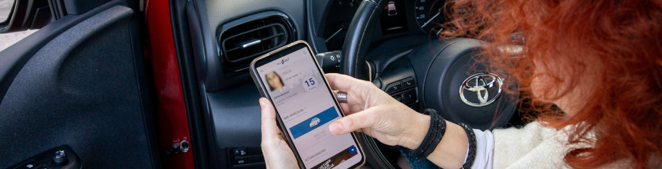 Mujer dentro de un vehículo mirando la aplicación de miDGT