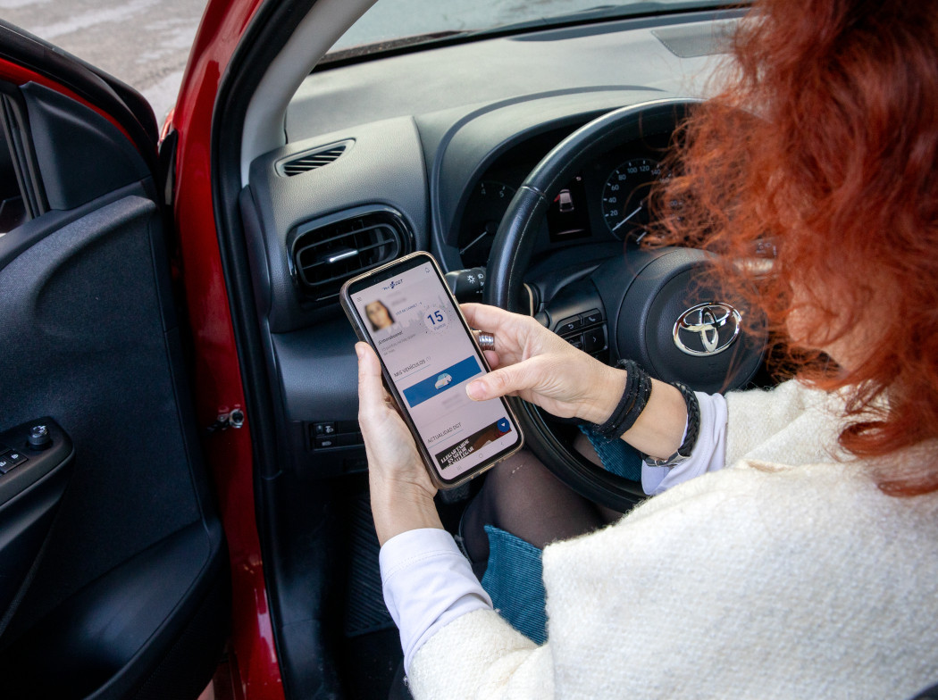 Mujer dentro de un vehículo viendo la aplicación móvil de la DGT