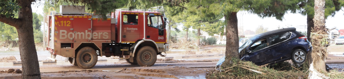 Coche de bomberos al lado de un coche accidentado DANA